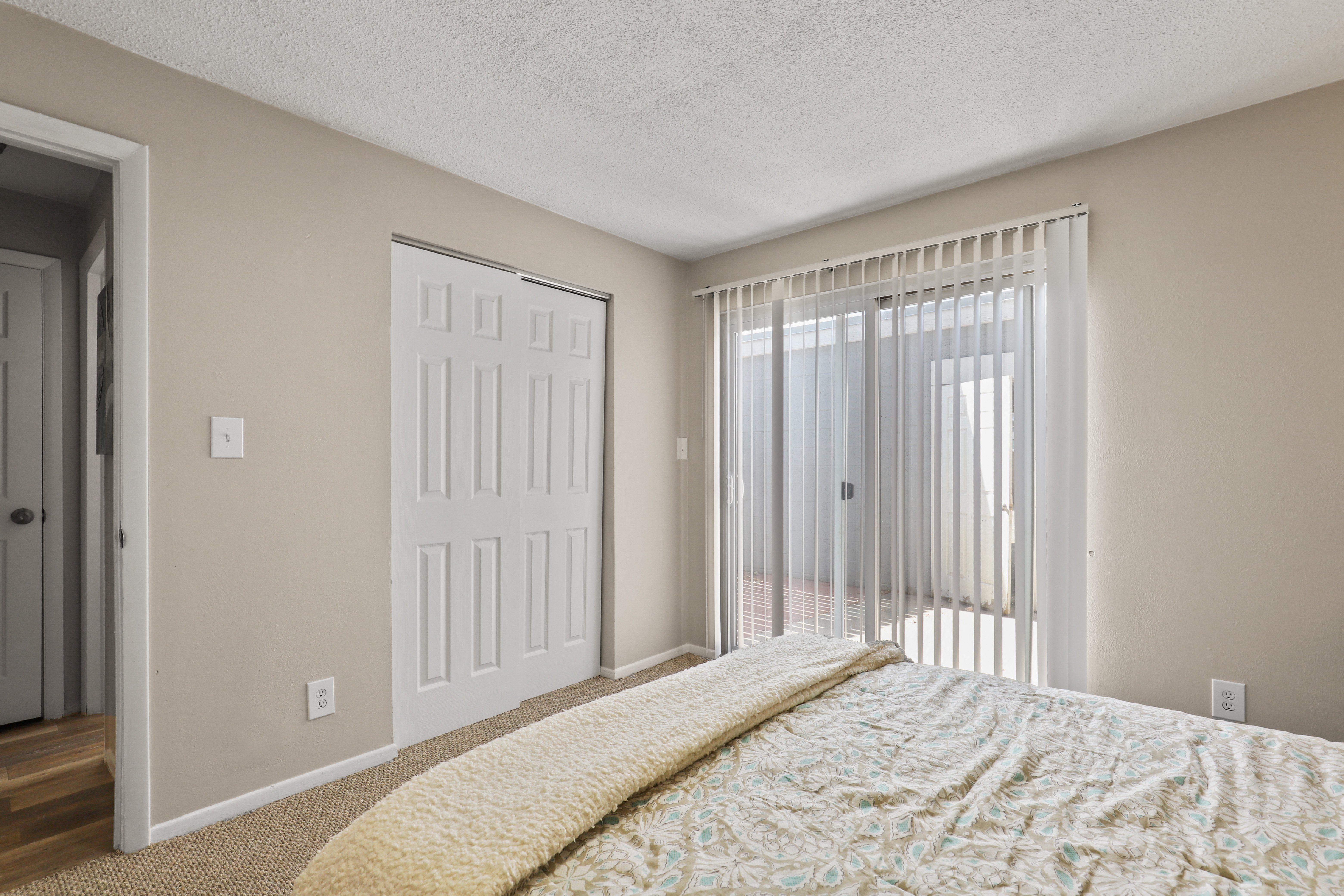 Large bedroom with sliding glass doors to a balcony